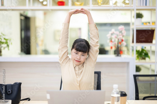 White-collar workers stretching and relaxing while sitting in office chairs
