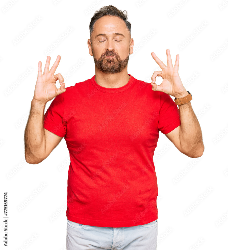 Handsome middle age man wearing casual red tshirt relax and smiling with eyes closed doing meditation gesture with fingers. yoga concept. Handsome middle age man wearing casual red tshirt relax and smiling with eyes closed doing meditation gesture with fingers. yoga concept.