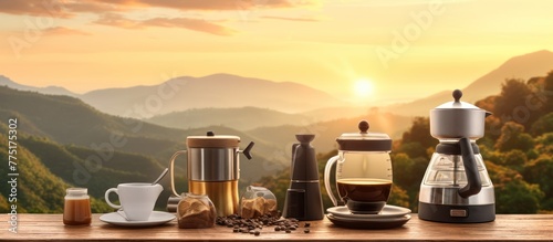 Outdoor coffee makers set on wooden table with natural mountain background and soft sunrise