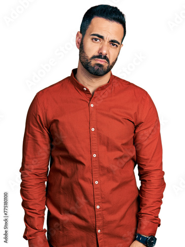 Young hispanic man with beard wearing casual shirt looking sleepy and tired, exhausted for fatigue and hangover, lazy eyes in the morning.