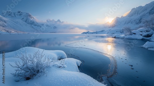 A snowy landscape with a lake and mountains in the background. The sun is setting, casting a warm glow on the water