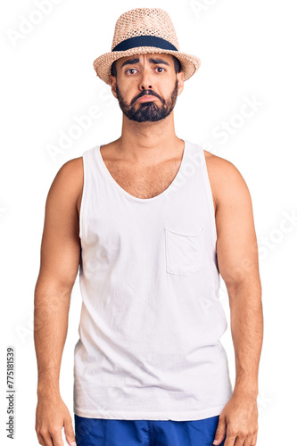 Young hispanic man wearing casual summer hat depressed and worry for distress, crying angry and afraid. sad expression.