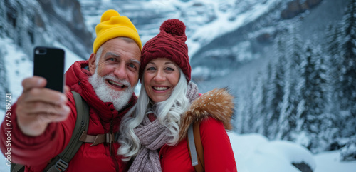Happy senior couple taking selfie using smartphone in winter time