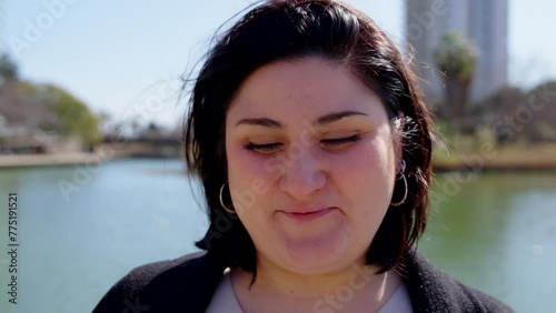 Closeup portrait of curvy woman laughing outdoors. Person looking at camera. photo