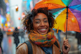 Young cheerful black woman with a contagious smile dances joyfully in the rain on a busy city street, holding vibrant colorful umbrella above her head. Autumn season concept