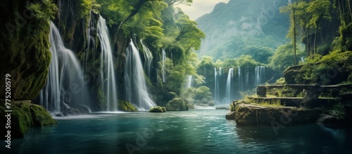 Amidst the rich greens of the forest lies a stunning waterfall cascading down with great force and beauty