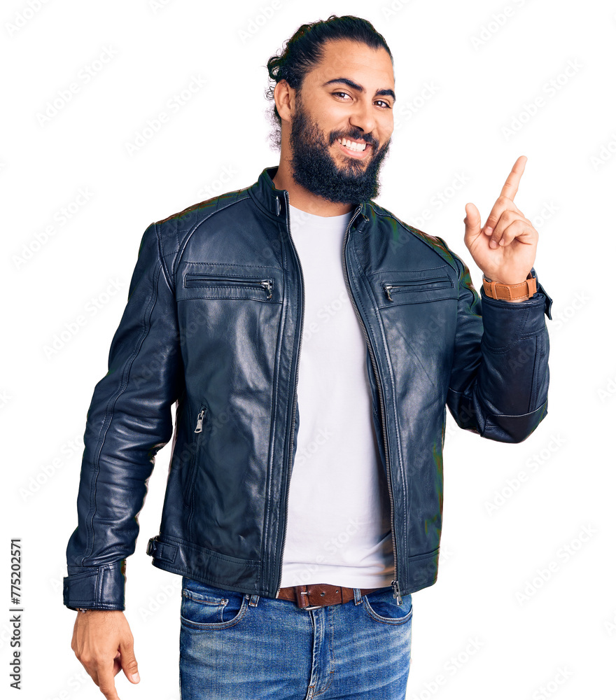 Young arab man wearing casual leather jacket with a big smile on face, pointing with hand finger to the side looking at the camera. Young arab man wearing casual leather jacket with a big smile on face, pointing with hand finger to the side looking at the camera.