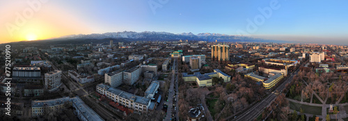 View from a quadcopter of the central part of the largest city of Kazakhstan - Almaty in the early spring morning against the backdrop of the Trans-Ili Alatau mountain range