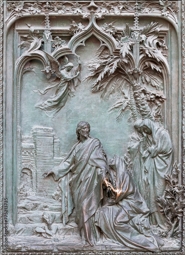 MILAN, ITALY - SEPTEMBER 16, 2024: The detail from main bronze gate of the Cathedral - Apparition to Mary Magdalen -  by Ludovico Pogliaghi (1906).