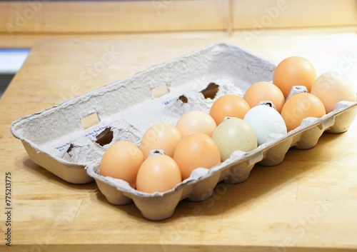 Fresh farm eggs mixed in color .