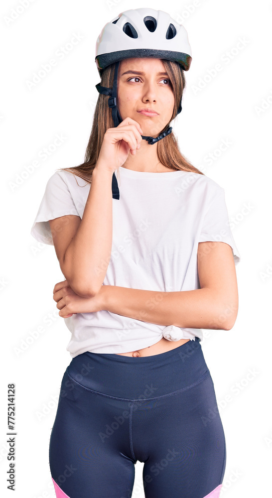 Young beautiful girl wearing bike helmet serious face thinking about question with hand on chin, thoughtful about confusing idea Young beautiful girl wearing bike helmet serious face thinking about question with hand on chin, thoughtful about confusing idea