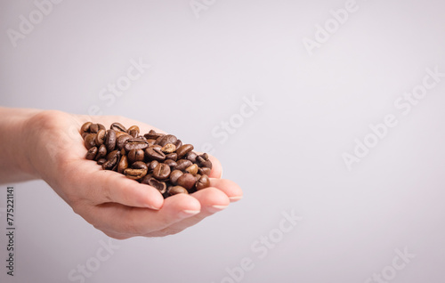coffee beans large in hand on a light background 