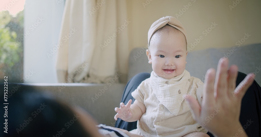Happy Mother and baby playing bonding activity together in living room. little cute Asian baby infant child girl excited laughing and fun spend quality time on sofa Family having fun at home Happy Mother and baby playing bonding activity together in living room. little cute Asian baby infant child girl excited laughing and fun spend quality time on sofa Family having fun at home