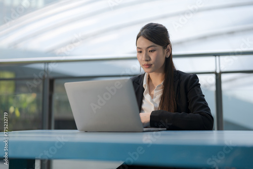 Professional woman working outdoors on laptop