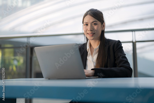 Professional woman working outdoors on laptop