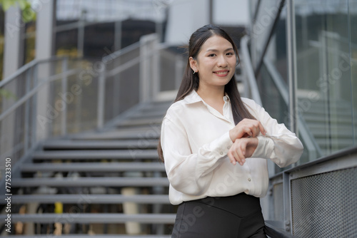 Professional woman in a white shirt poses confidently by the stairs © Naypong Studio