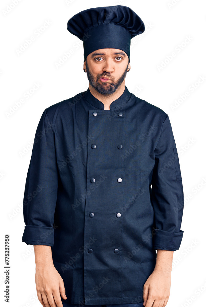 Young hispanic man wearing cooker uniform depressed and worry for distress, crying angry and afraid. sad expression. Young hispanic man wearing cooker uniform depressed and worry for distress, crying angry and afraid. sad expression.