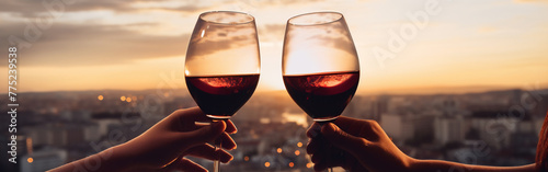Two female hands toasting or clinking with red wine glasses on a city and minimalist background  photo