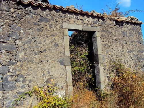 Vecchia casa di campagna abbandonata della zona etnea della Sicilia, con erba cresciuta al suo interno. photo