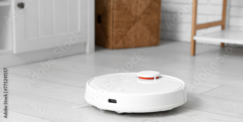 Modern robot vacuum cleaner on floor in living room