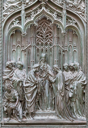 MILAN, ITALY - SEPTEMBER 16, 2024: The detail from main bronze gate of the Cathedral - Spouse of St. Joseph and Virgin Mary -  by Ludovico Pogliaghi (1906). photo
