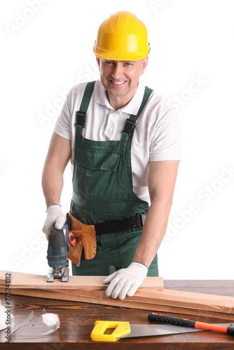 Mature carpenter sawing wooden plank at table on white background