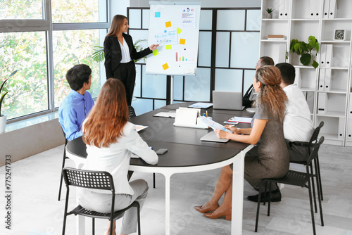 Young businesswoman giving presentation to her colleagues in office photo