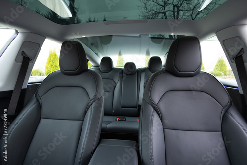 Luxury car leather seats. Interior of new modern clean expensive car. Passenger seats with leather. Closeup details. New car inside. Car cleaning theme. Panoramic glass sun roof.