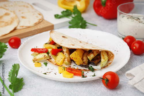 Plate of tasty pita bread with grilled vegetables on white background photo
