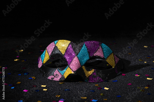 Carnival mask with glitters on black background.