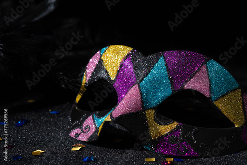 Carnival mask with glitters on black background.