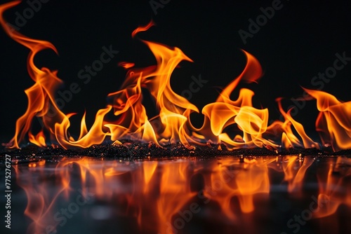 Dynamic orange and red flames lick upwards against a deep black background, creating a sense of power and destruction. photo