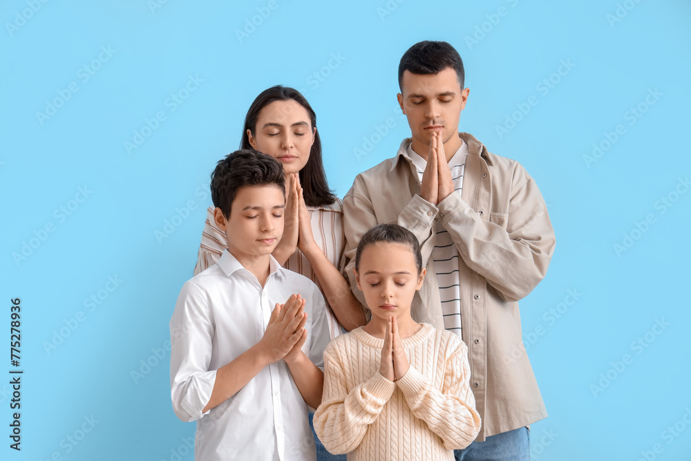 Family praying together on blue background