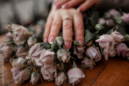 close-up of female hands holding a bouquete with roses photo