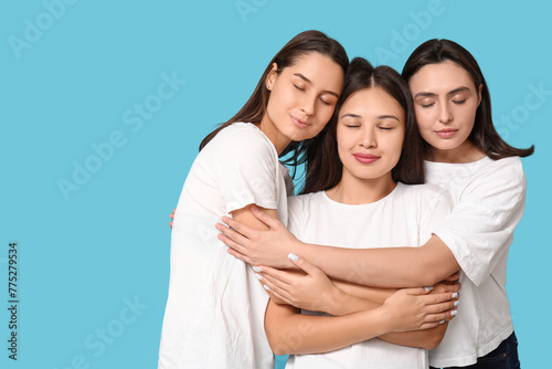 Portrait of hugging women on blue background. Women history month