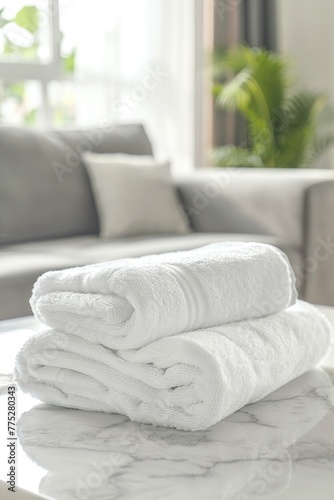 Neat stack of white towels on a table, suitable for spa or hotel concepts © Fotograf