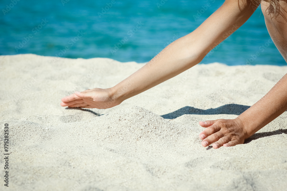 A hands pouring sand near the seashore on weekend nature travel A hands pouring sand near the seashore on weekend nature travel