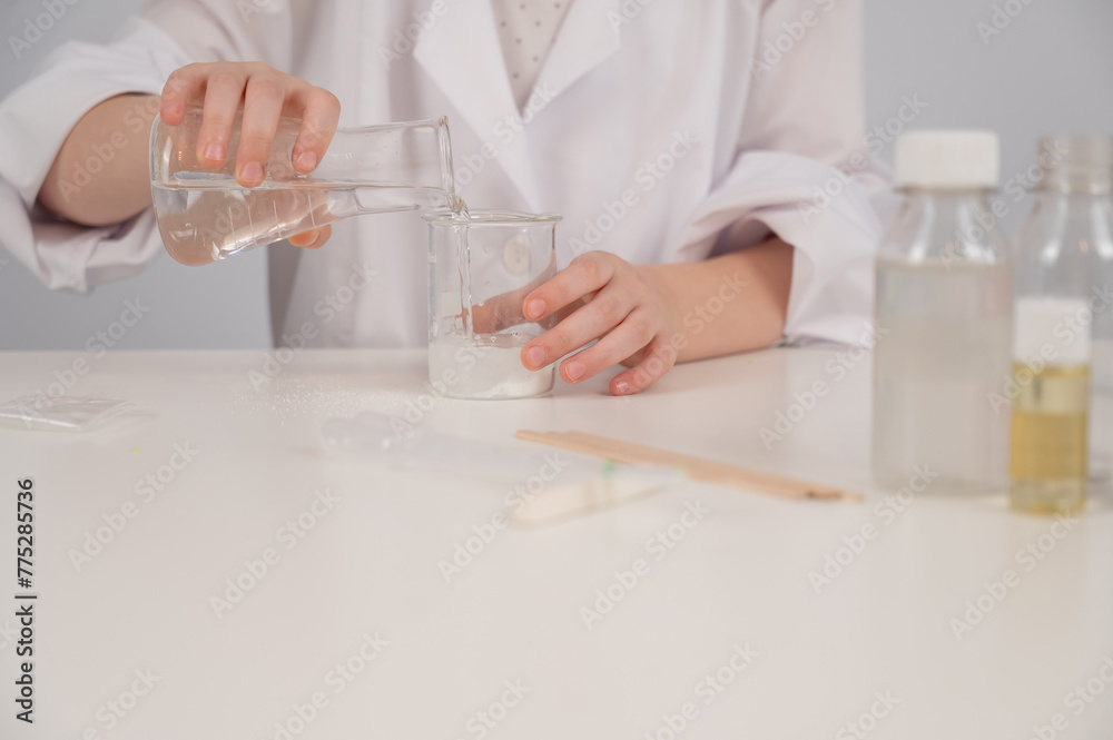 Faceless girl doing chemical experiments on a white background. Faceless girl doing chemical experiments on a white background.