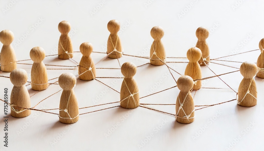 Fototapeta premium A group of wooden people are connected by strings, forming a network. Concept of interconnectedness and collaboration, as the people are all linked together