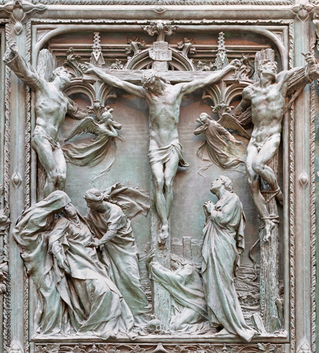 MILAN, ITALY - SEPTEMBER 16, 2024: The detail from main bronze gate of the Cathedral -   Crucifixion by Ludovico Pogliaghi (1906). photo