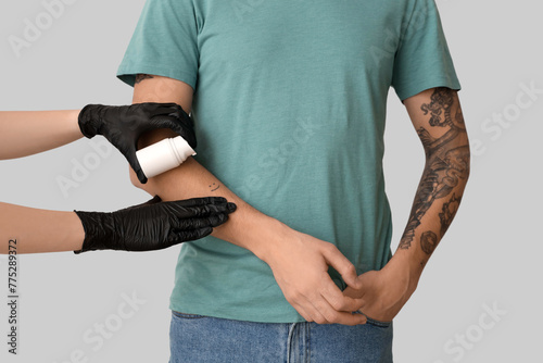 Tattoo master applying crea...