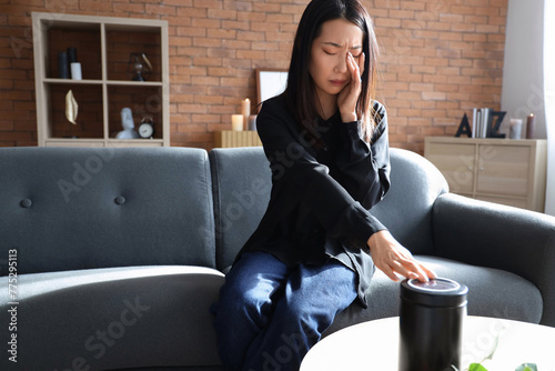 Grieving young Asian woman with mortuary urn at funeral photo