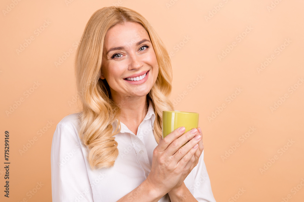 Photo of good mood dreamy woman wear white shirt enjoying beverage empty space isolated beige color background Photo of good mood dreamy woman wear white shirt enjoying beverage empty space isolated beige color background