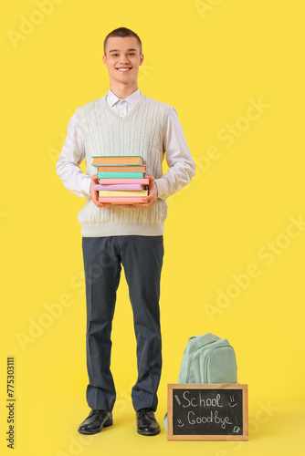 Smiling male student holdin...