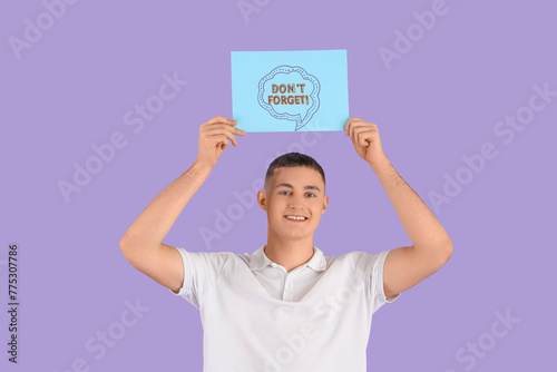 Young man holding paper wit...