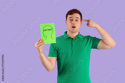 Young man holding paper wit...