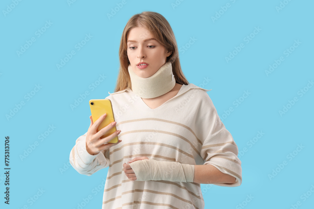Injured young woman after accident with mobile phone on blue background