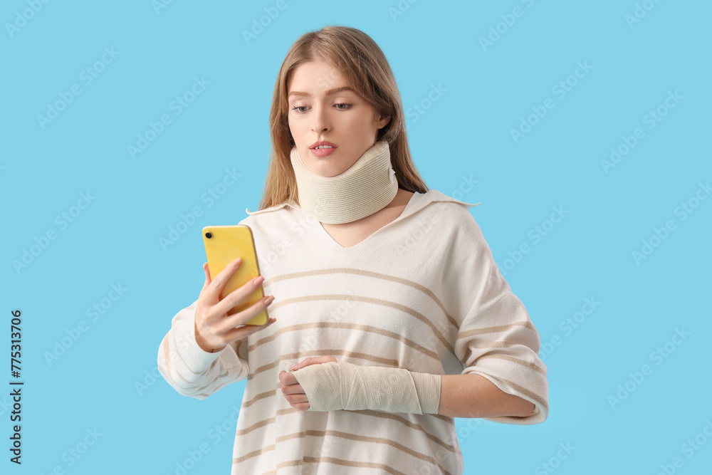 Injured young woman after accident with mobile phone on blue background Injured young woman after accident with mobile phone on blue background