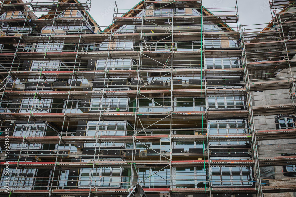 Building under construction. Site with scaffolding. Building under construction. Site with scaffolding.
