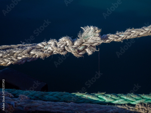 Knots on a tense mooring line. Fastening the ship to the shore. Tight rope. Shipbuilding concept